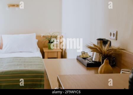 Intérieur d'une chambre d'hôtel simple et joliment meublée lit simple en journée Banque D'Images