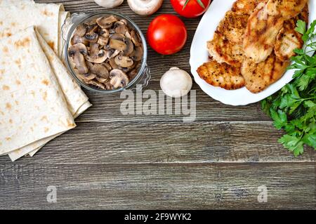 Ingrédients du shawarma. Pain pita fin, viande grillée, légumes frais, herbes, champignons pour des petits pains savoureux et sains. Copier l'espace Banque D'Images