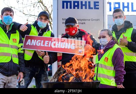 Wustermark, Allemagne. 21 avril 2021. Les employés en service de Mahle Filtersysteme GmbH et les représentants d'IG Metall se tiennent derrière un foyer à l'entrée de l'entreprise ce matin lors d'une grève d'avertissement d'IG Metall avec un panneau indiquant « alignement ». L’action, qui a duré plus de trois quarts, avait pour but, entre autres, de donner du poids aux demandes d’augmentation de salaire et aux futures conventions collectives. Credit: Soeren Stache/dpa-Zentralbild/ZB/dpa/Alay Live News Banque D'Images