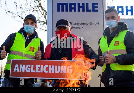 Wustermark, Allemagne. 21 avril 2021. Les employés en service de Mahle Filtersysteme GmbH et les représentants d'IG Metall se tiennent derrière un foyer à l'entrée de l'entreprise ce matin lors d'une grève d'avertissement d'IG Metall avec un panneau indiquant « alignement ». L’action, qui a duré plus de trois quarts, avait pour but, entre autres, de donner du poids aux demandes d’augmentation de salaire et aux futures conventions collectives. Credit: Soeren Stache/dpa-Zentralbild/ZB/dpa/Alay Live News Banque D'Images