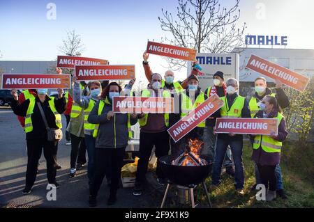 Wustermark, Allemagne. 21 avril 2021. Les employés en service de Mahle Filtersysteme GmbH et les représentants d'IG Metall se tiennent derrière un foyer à l'entrée de l'entreprise ce matin lors d'une grève d'avertissement d'IG Metall avec un panneau indiquant « alignement ». L’action, qui a duré plus de trois quarts, avait pour but, entre autres, de donner du poids aux demandes d’augmentation de salaire et aux futures conventions collectives. Credit: Soeren Stache/dpa-Zentralbild/ZB/dpa/Alay Live News Banque D'Images