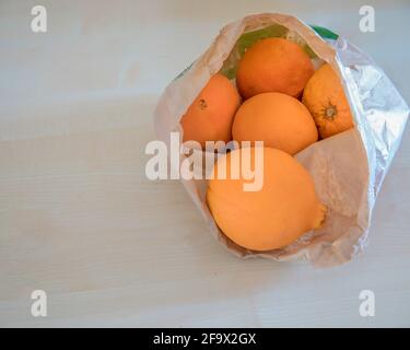 Oranges dans un sac en papier. Copy Space.cinq oranges fraîches à l'intérieur d'un sac de papier d'épicerie. Isolé. Image de stock. Banque D'Images