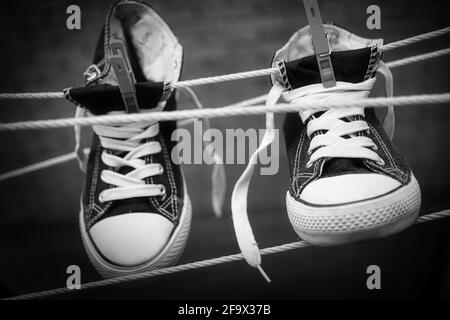 Baskets à prise de vue en niveaux de gris accrochées à une corde avec des épingles à linge Banque D'Images