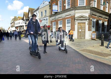 Canterbury, Kent, Royaume-Uni. Deux garçons sur DES SCOOTERS ÉLECTRIQUES D'OISEAU dans Canterbury High Street Banque D'Images