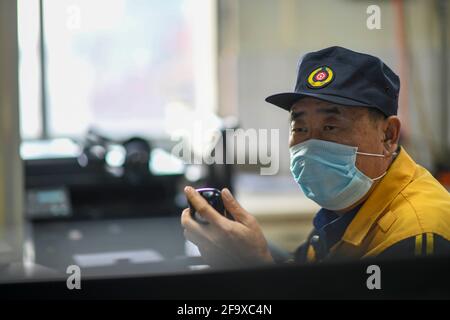 (210421) -- URUMQI, le 21 avril 2021 (Xinhua) -- Niu Xinyuan est en service à la station Hongguang, dans la ville de Hami, dans la région autonome de Xinjiang, dans le nord-ouest de la Chine, le 24 février 2021. Un relais de carrière de trois générations sur 70 ans au sein de la même famille a été témoin du développement étonnant du transport ferroviaire dans la région autonome du Xinjiang dans le nord-ouest de la Chine. Xinjiang a toujours été bien noté pour son environnement géologique et climatique rigoureux, allant de vastes déserts, des montagnes enneigées, des vents dévastateurs, aux marais salés, tous des ennemis naturels à la construction de chemins de fer Banque D'Images