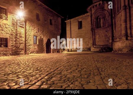 Photo nocturne d'une allée solitaire de l'époque médiévale avec des planchers de pavés et des murs de pierre dans la belle ville Cantabrique de Santillana del Mar. Banque D'Images