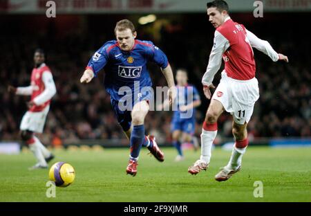 Wayne rooney de Manchester United passe le ballon devant Robin Van Persie. Banque D'Images