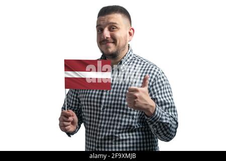 Homme blanc tenant un drapeau de la Lettonie et montre la classe à la main isolée sur un fond blanc. Comme pour la Lettonie. Banque D'Images