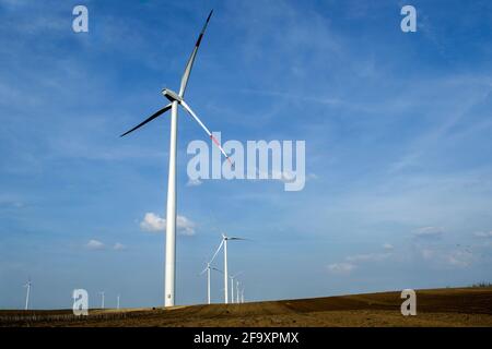 L'éolienne est un dispositif qui convertit l'énergie cinétique du vent en électricité, dans les champs à Alibunar, le Banat, en Serbie. Banque D'Images