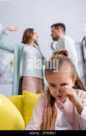 Pleurs enfants assis près de parents flous quereling Banque D'Images