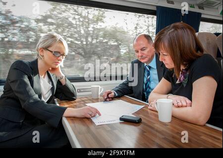 Groupe de personnes tenant une réunion d'affaires sur un train. Banque D'Images