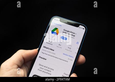 Kharkov, Ukraine - 20 avril 2021: Application Google Drive, homme utiliser iPhone avec l'application de stockage en ligne sur fond noir Banque D'Images