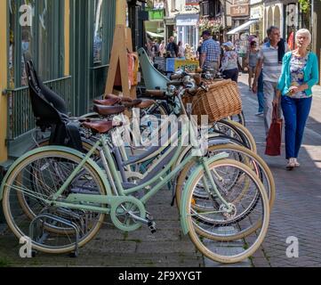 Idée de Staycation. Une rangée de vélos garés devant Bells Bicycles et des personnes marchant sur George Street, dans la vieille ville de Hastings, un jour d'été. Angleterre. Banque D'Images