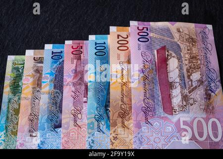 Nouveaux billets de banque Riyal qatari sur fond noir Banque D'Images