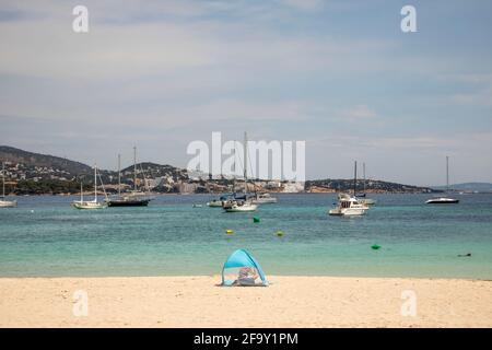 Palmanova, Majorque, Espagne. 20 avril 2021. Vue sur la plage d'une femme et d'une tente à vent en face de la mer et des bateaux à Pamanova à Majorque. Credit: John-Patrick Morarescu/ZUMA Wire/Alamy Live News Banque D'Images