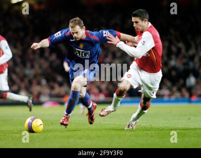 Wayne Rooney de Manchester United passe le ballon devant Robin Van Persie. Banque D'Images