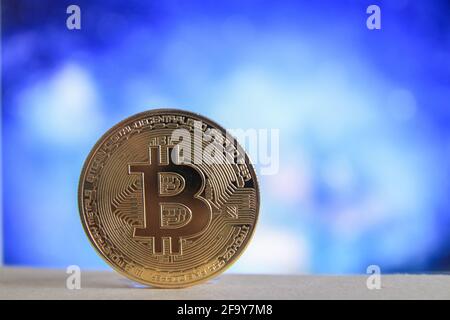 Une version physique de Bitcoin BTC avec un arrière-plan bleu flou. Banque D'Images