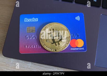 Berlin, Allemagne - 21 avril 2021: Revolut Mastercard et une devise bitcoin sur ordinateur portable.Revolut est un moyen rapide, simple et facile d'acheter, de vendre, et Banque D'Images