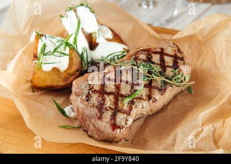 Steak de bœuf grillé avec pommes de terre sur bois Banque D'Images