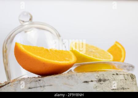 Citron et orange sur la souche à côté de la cloche de verre. Aliments sains. Banque D'Images
