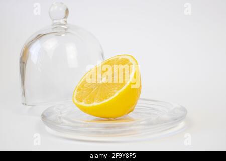 Un demi de citron à côté de la cloche en verre. Banque D'Images
