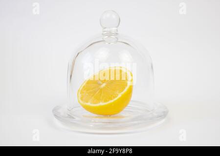 Un demi de citron à côté de la cloche en verre. Banque D'Images