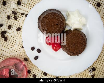 Crème caramel dessert ou café Flan a avec cerise et une cuillère en métal sur une assiette décorée de grains de café Banque D'Images