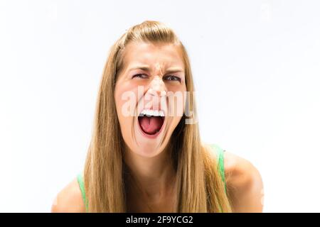 Portrait d'une jeune femme blonde criant sur fond blanc Banque D'Images
