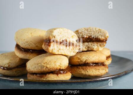 Biscuits Alfahores au lait condensé sur une assiette grise. Biscuits maison traditionnels. Concept de cuisine maison. Orientation horizontale. Gros plan. Banque D'Images