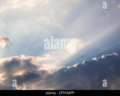 Rayons crépusculaires du soleil couchant à travers les nuages causés par des particules dans l'atmosphère. Banque D'Images