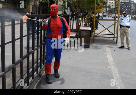 Mumbai, Inde. 21 avril 2021. Un homme habillé comme Spider Man désinfecte une rampe de fer à l'extérieur de Chhatrapati Shivaji Maharaj Terminus, comme précaution contre la propagation du coronavirus. Crédit : SOPA Images Limited/Alamy Live News Banque D'Images