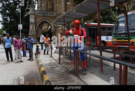 Mumbai, Inde. 21 avril 2021. Un homme habillé comme Spider Man désinfecte un abri de bus à l'extérieur de Chhatrapati Shivaji Maharaj Terminus, comme précaution contre la propagation du coronavirus. Crédit : SOPA Images Limited/Alamy Live News Banque D'Images