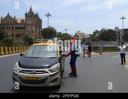 Mumbai, Inde. 21 avril 2021. Un homme habillé comme Spider Man désinfecte un taxi à l'extérieur de Chhatrapati Shivaji Maharaj Terminus, comme précaution contre la propagation du coronavirus. Crédit : SOPA Images Limited/Alamy Live News Banque D'Images