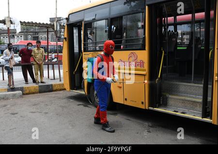 Mumbai, Inde. 21 avril 2021. Un homme habillé comme Spider Man désinfecte un bus de transport en commun à l'extérieur de Chhatrapati Shivaji Maharaj Terminus, par mesure de précaution contre la propagation du coronavirus. Crédit : SOPA Images Limited/Alamy Live News Banque D'Images