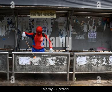 Mumbai, Inde. 21 avril 2021. Un homme habillé comme Spider Man désinfecte un abri de bus à l'extérieur de Chhatrapati Shivaji Maharaj Terminus, comme précaution contre la propagation du coronavirus. (Photo par Ashish Vaishnav/SOPA Images/Sipa USA) crédit: SIPA USA/Alay Live News Banque D'Images