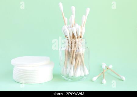 Écouvillons en coton biologique de bambou dans un pot en verre et des tampons de coton pour une hygiène personnelle, vue du dessus Banque D'Images