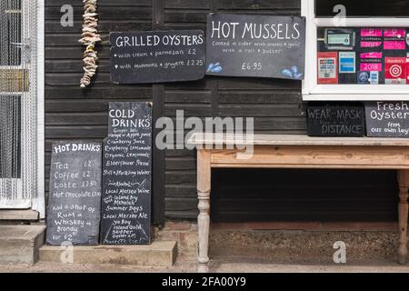 Fruits de mer Essex, vue sur les menus à l'extérieur de la compagnie Shed sur Mersea Island, un restaurant local réputé pour ses fruits de mer frais, Mersea, Essex. Banque D'Images