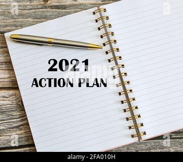 Vue de dessus d'un stylo avec plan d'action 2021 écrit sur un bloc-notes. Banque D'Images