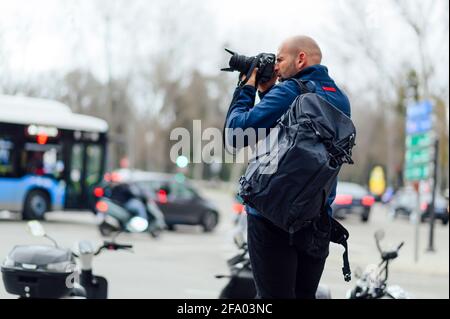 photographe professionnel prenant une photo dans la rue Banque D'Images