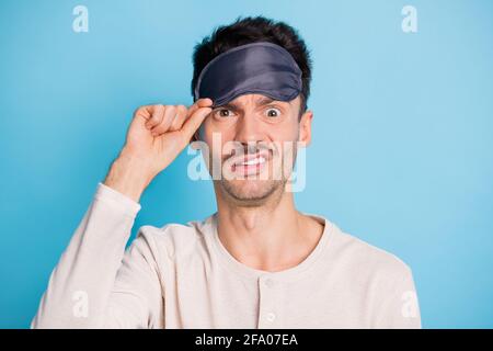 Portrait en gros plan de funky irrité mature gars mettant le sommeil des yeux masque sur fond bleu vif isolé Banque D'Images