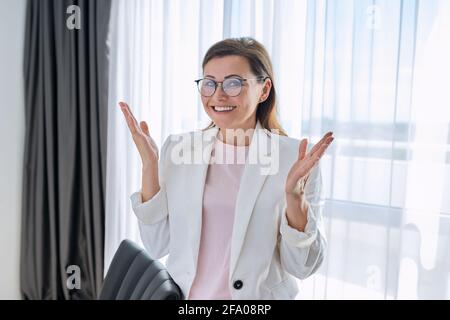 Bonne femme d'affaires émotive regardant la caméra dans le bureau Banque D'Images