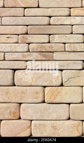 L'arrière-plan et la texture du mur sont faits de grès de vent avec des bords arrondis. Image verticale, gros plan. Banque D'Images
