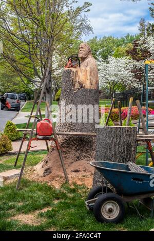 04 14 2021 Tulsa USA Bigfoot est sculpté dans une souche d'arbre avec une chaise, des échelles et d'autres équipements dans un quartier résidentiel au printemps. Banque D'Images