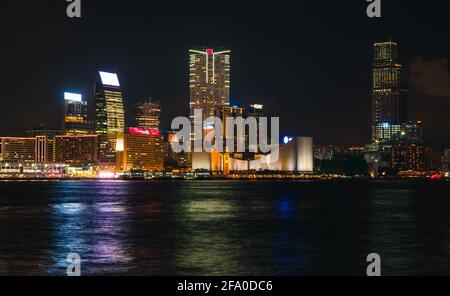 Vue nocturne sur Hong Kong, vue sur le quartier central avec gratte-ciel illuminés sur la côte, paysage urbain sombre avec reflets colorés dans l'eau Banque D'Images