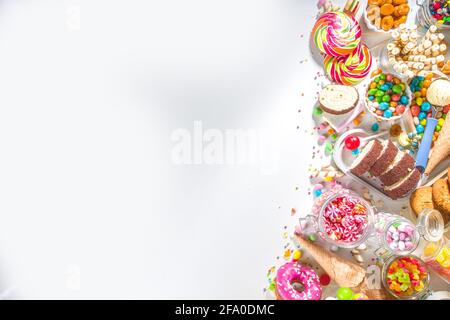 Sélection de bonbons colorés. Assortiment de bonbons, chocolats, beignets, biscuits, sucettes, vue de dessus de crème glacée sur fond blanc Banque D'Images