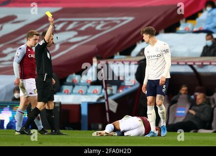 L'arbitre Peter Bankes montre une carte jaune initiale à John Stones de Manchester City après un défi sur Jacob Ramsey de Aston Villa, qui a ensuite été examiné par VAR et a été surclassé à un rouge droit pendant le match de la Premier League à Villa Park, Birmingham. Date de la photo: Mercredi 21 avril 2021. Banque D'Images