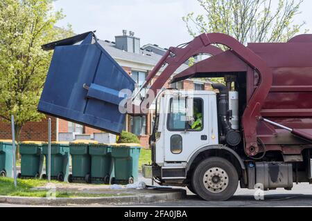 Camion rouge avec un conteneur de ménage de chargement entretien à domicile public services Banque D'Images