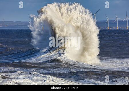 Une énorme vague avec des éoliennes au loin. Hartlepool, Angleterre, Royaume-Uni. Banque D'Images