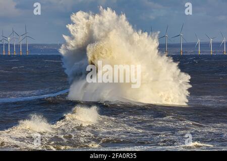 Une énorme vague avec des éoliennes au loin. Hartlepool, Angleterre, Royaume-Uni. Banque D'Images