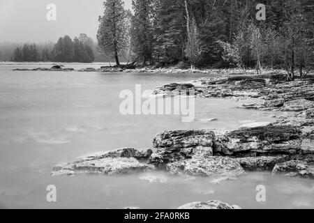 Une ligne de rivage escarpée le long du lac Michigan dans le comté de Door, Wisconsin, photographiée comme une longue exposition noire et blanche lors d'un après-midi de printemps brumeux. Banque D'Images